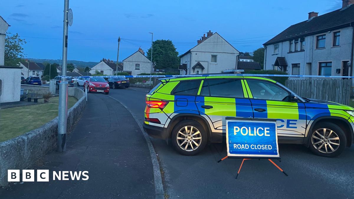 A police cordon in the area. There is a police car, tape and a road closed sign