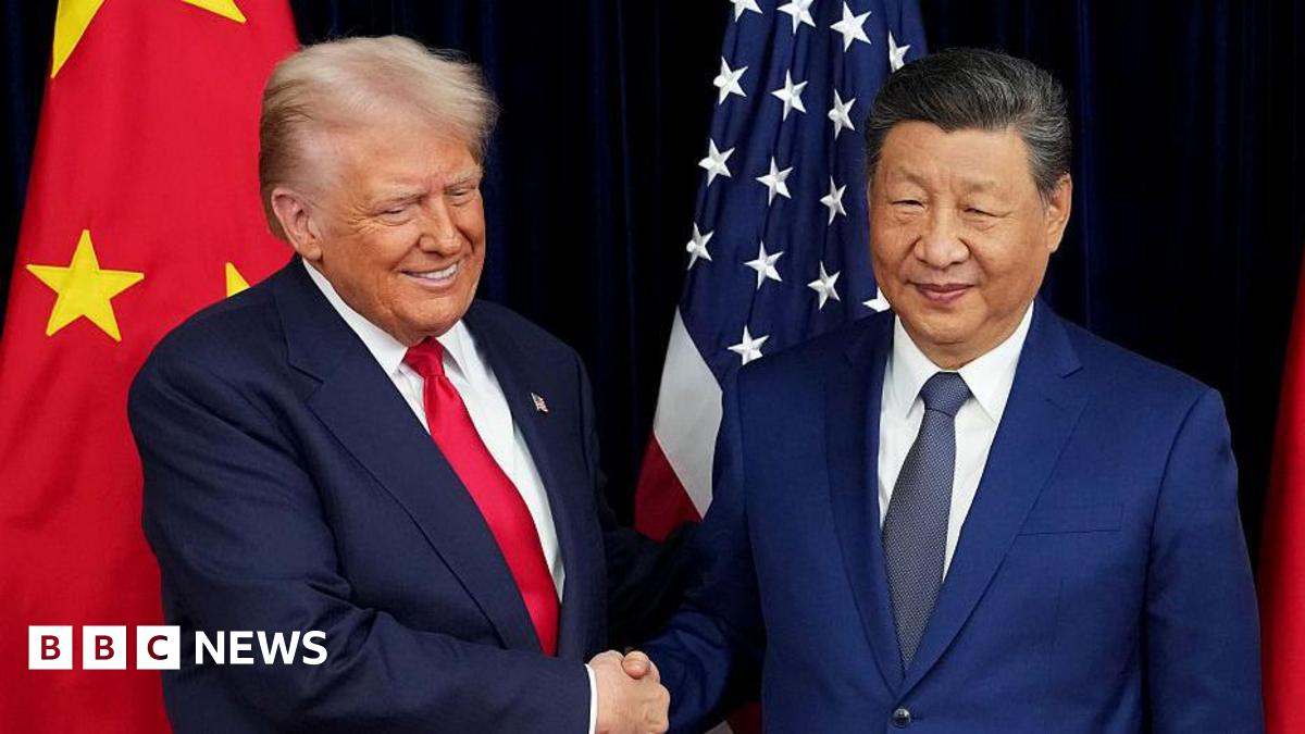 US President Donald Trump exchanges a handshake with Chinese President Xi Jinping while posing for pictures in front of their countries' national flags