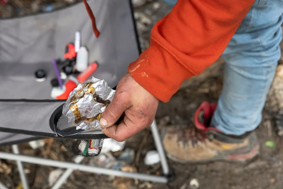 A homeless man holding a piece of aluminum foil used to smoke fentanyl in Seattle