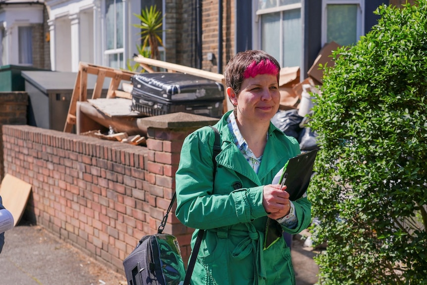 A woman with a clipboard walking.