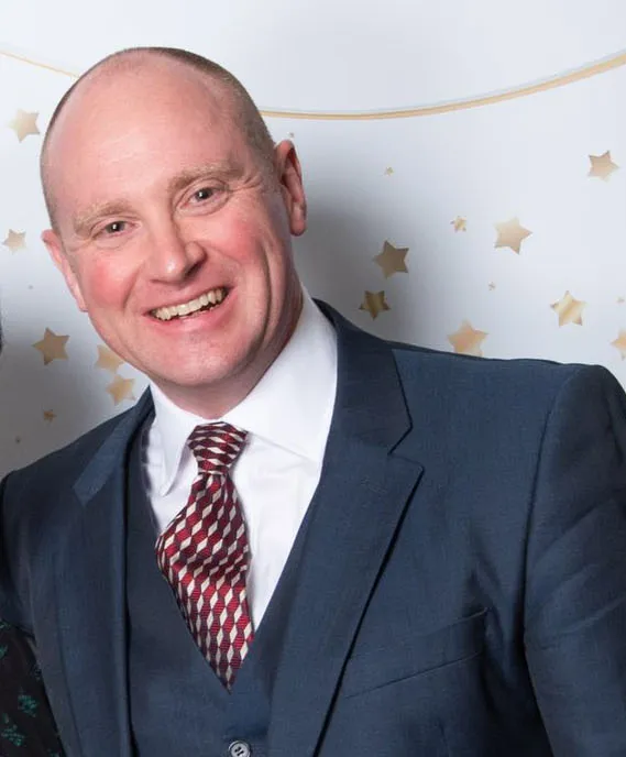 James Gilbert, Transplant Surgeon and "Doctor of the Year" finalist, smiles and holds his award.