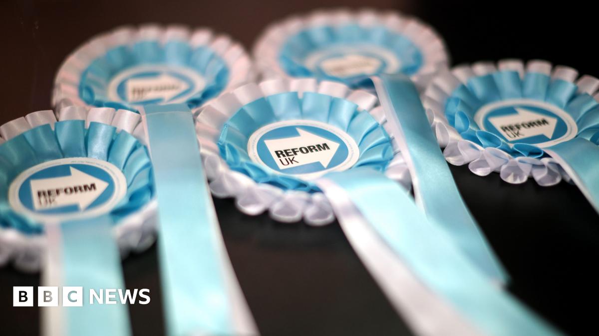 A close-up of five Reform UK election rosettes in turquoise blue and white colours.