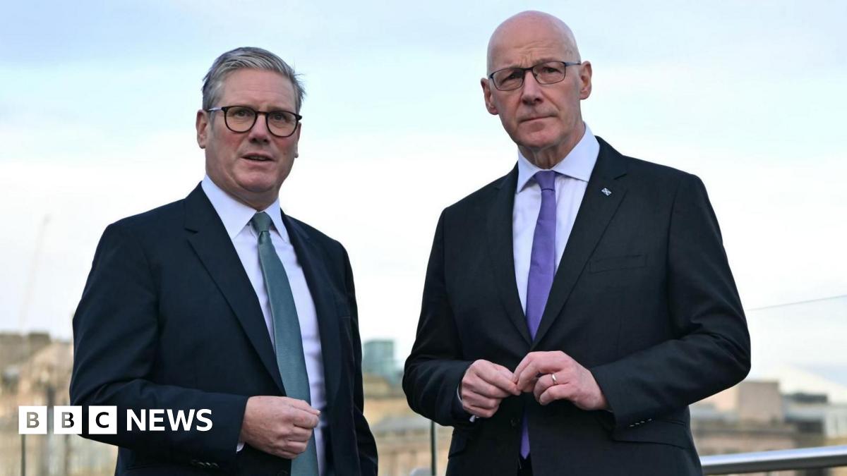 Sir Keir Starmer and John Swinney. Sir Keir has grey hair and Swinney has a bald head. They are both wearing glasses and dark suits with white shirts. Sir Keir is wearing a blue tie and Swinney a purple tie.