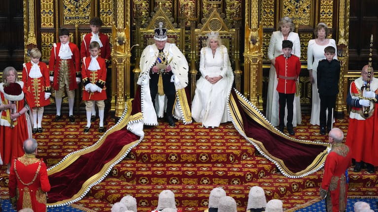 Britain's King Charles III reads out as he sits besides Queen Camilla during the State Opening of Parliament at the Palace of Westminster in London