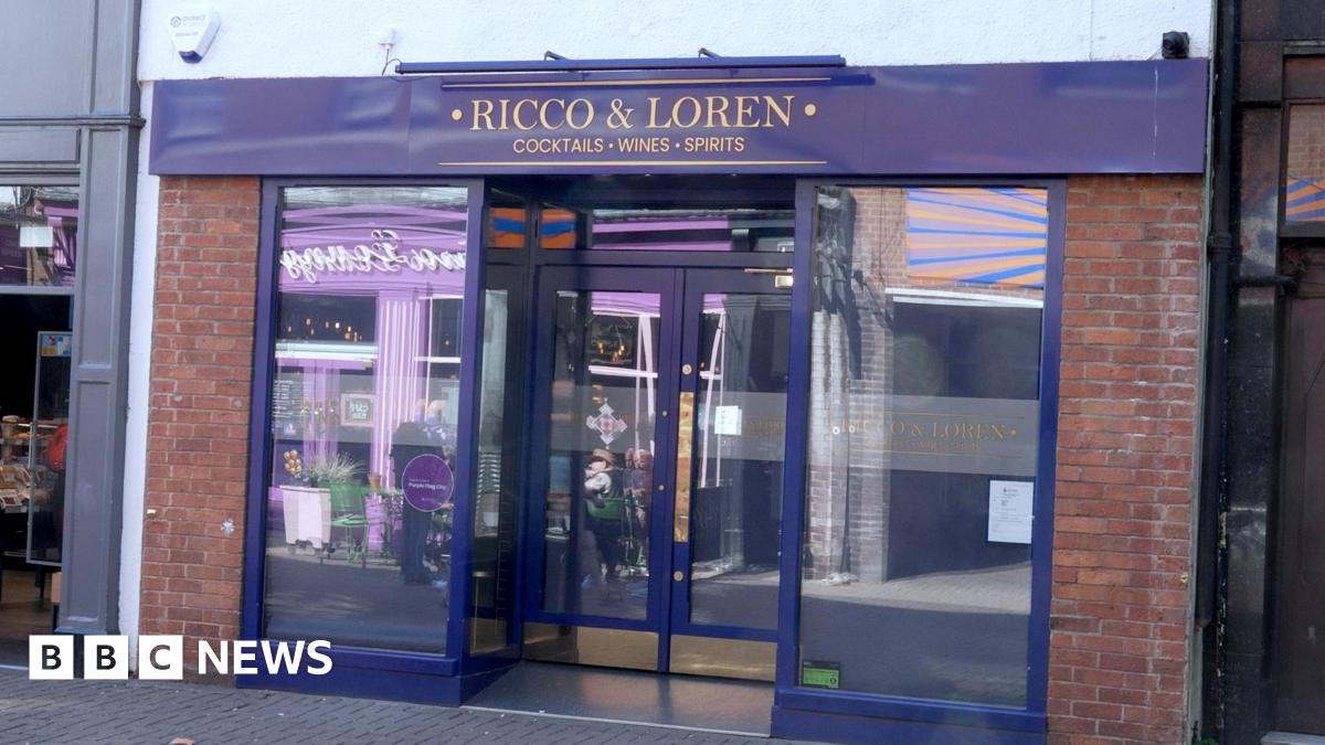 A purple shop front with "Ricco & Loren - cocktails, wines, sprits" written in gold lettering on a fascia board above the doors.