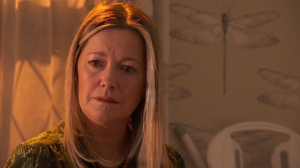 Hollyoaks Diane Hutchinson crying hollyoaks diane hutchinson crying in front of the curtains with soft orange lighting and a propped up ironing board behind her