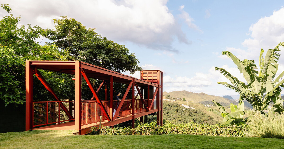 red elevated metal walkway extends casa castela across steep brazilian slope