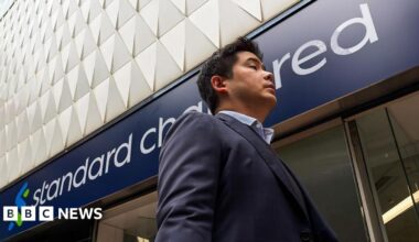 A pedestrian walks past a Standard Chartered bank branch on 17 March, 2026 in Hong Kong.