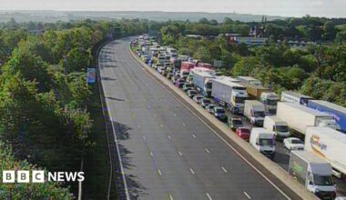 An overhead view of a motorway, where one side is heavily congested with traffic.