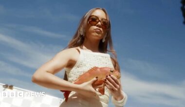 Laufey, framed against a sunny Californian sky, holds a red snapper while preparing to film a music video for her single Mad Woman
