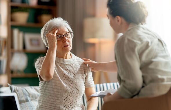 Concerned Senior Woman Being Comforted by Caregiver at Home Concerned Senior Woman Being Comforted by Caregiver at Home