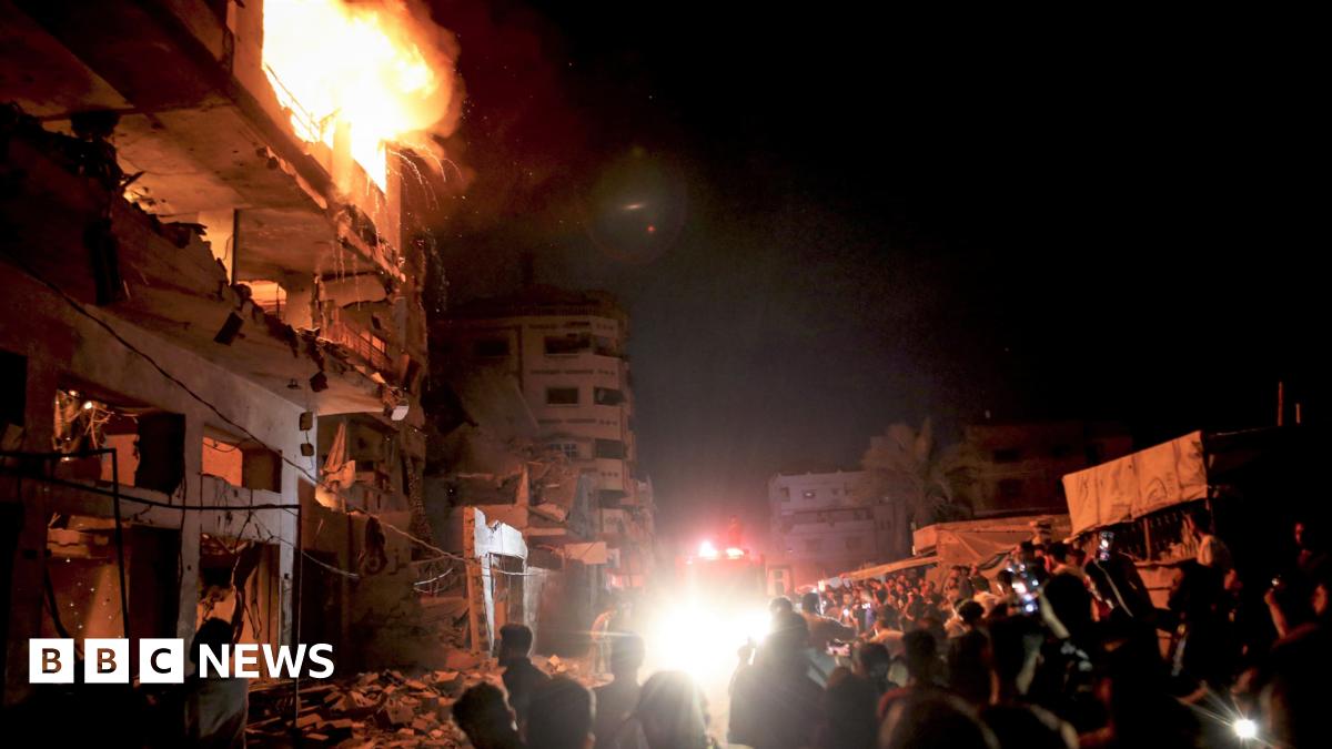 People look on as a fire burns in a building in central Gaza City.