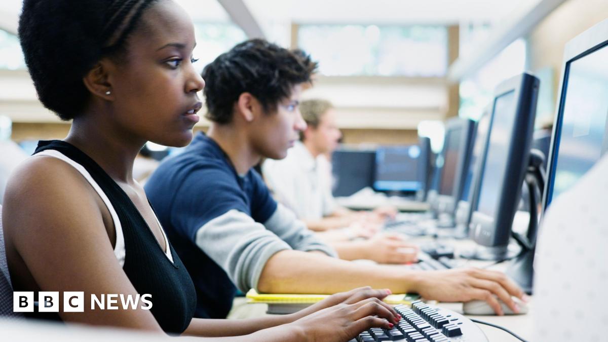 A stock image of US university students in exams. There are a row of students in front of computers