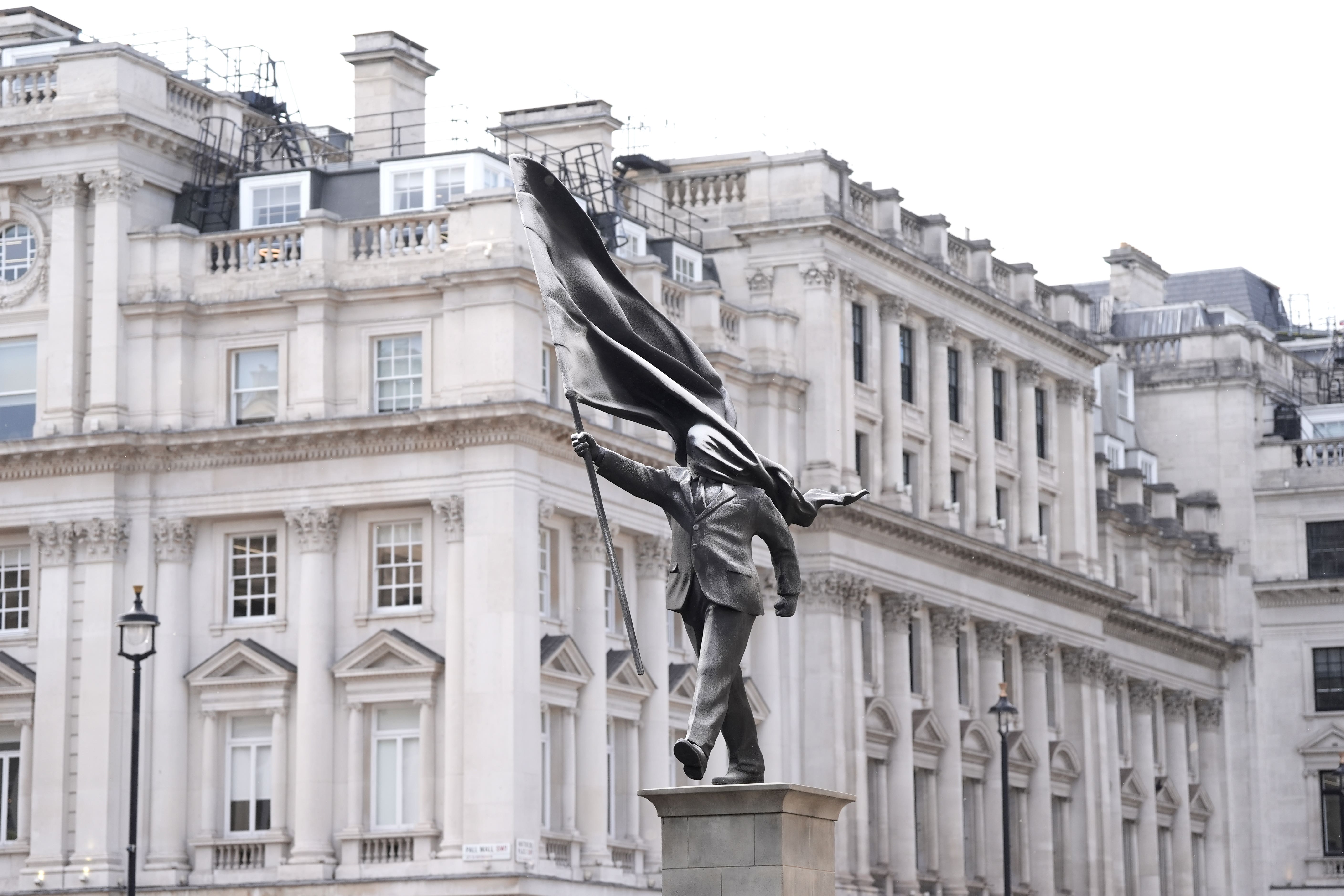 A statue of a man holding a flag which covers their face, and signed ‘Banksy’, has appeared in Waterloo Place in central London (Stefan Rousseau/PA)