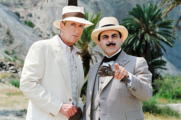 David Suchet as Hercule Poirot standing next to Hugh Fraser as Captain Hastings in linen suits looking into the camera.