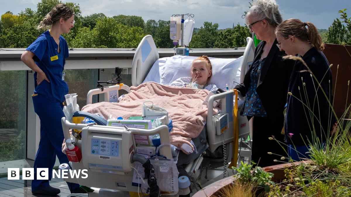 Hollie, 29, a patient at King's College Hospital, is wheeled onto the new rooftop intensive care unit in south London in her hospital bed, surrounded by three nurses dressed in blue uniforms.
