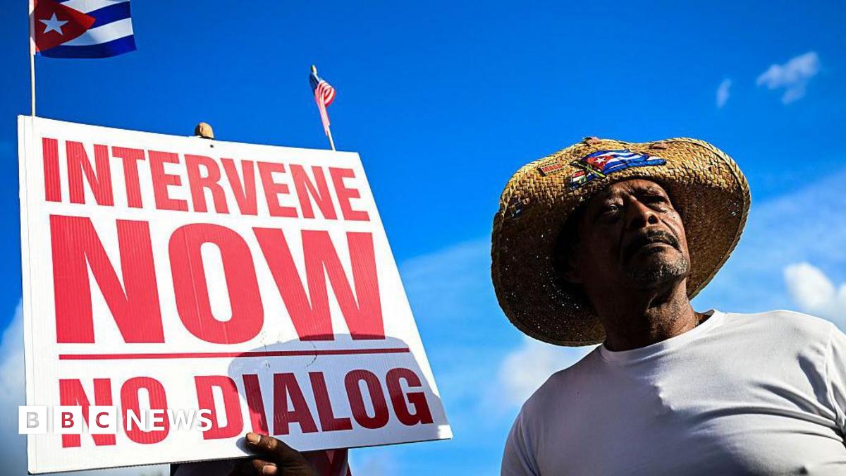 Man holding an "intervene now" sign in Miami, Florida.