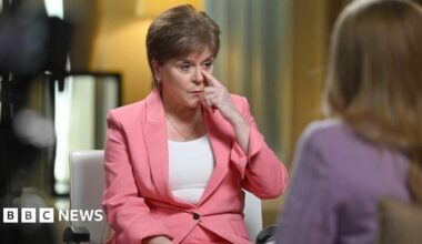 Nicola Sturgeon speaks to Laura Kuenssberg, who is out of shot. Sturgeon is wearing a white top and pink suit
