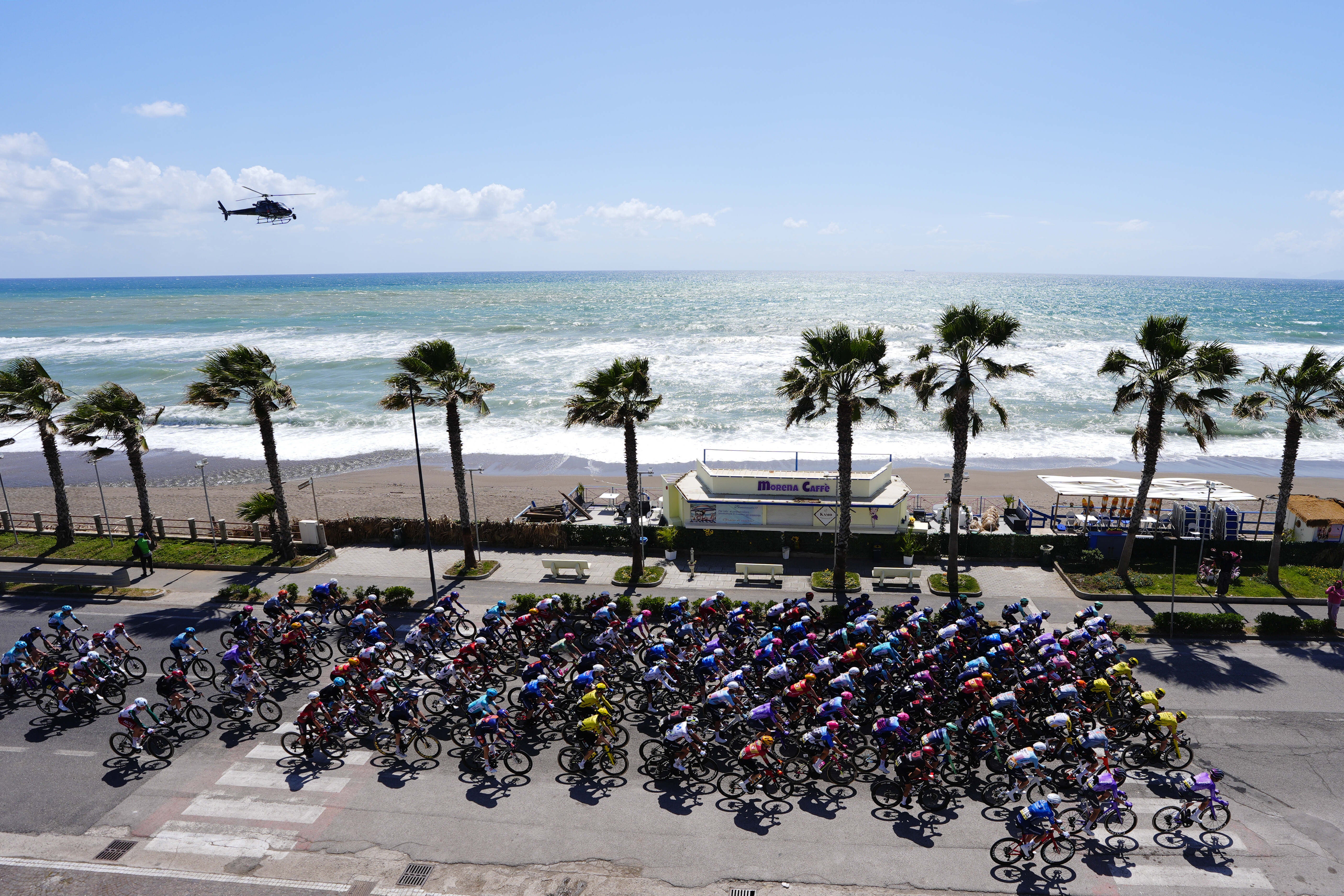 Aerial view of the peloton riding along the coast to Naples