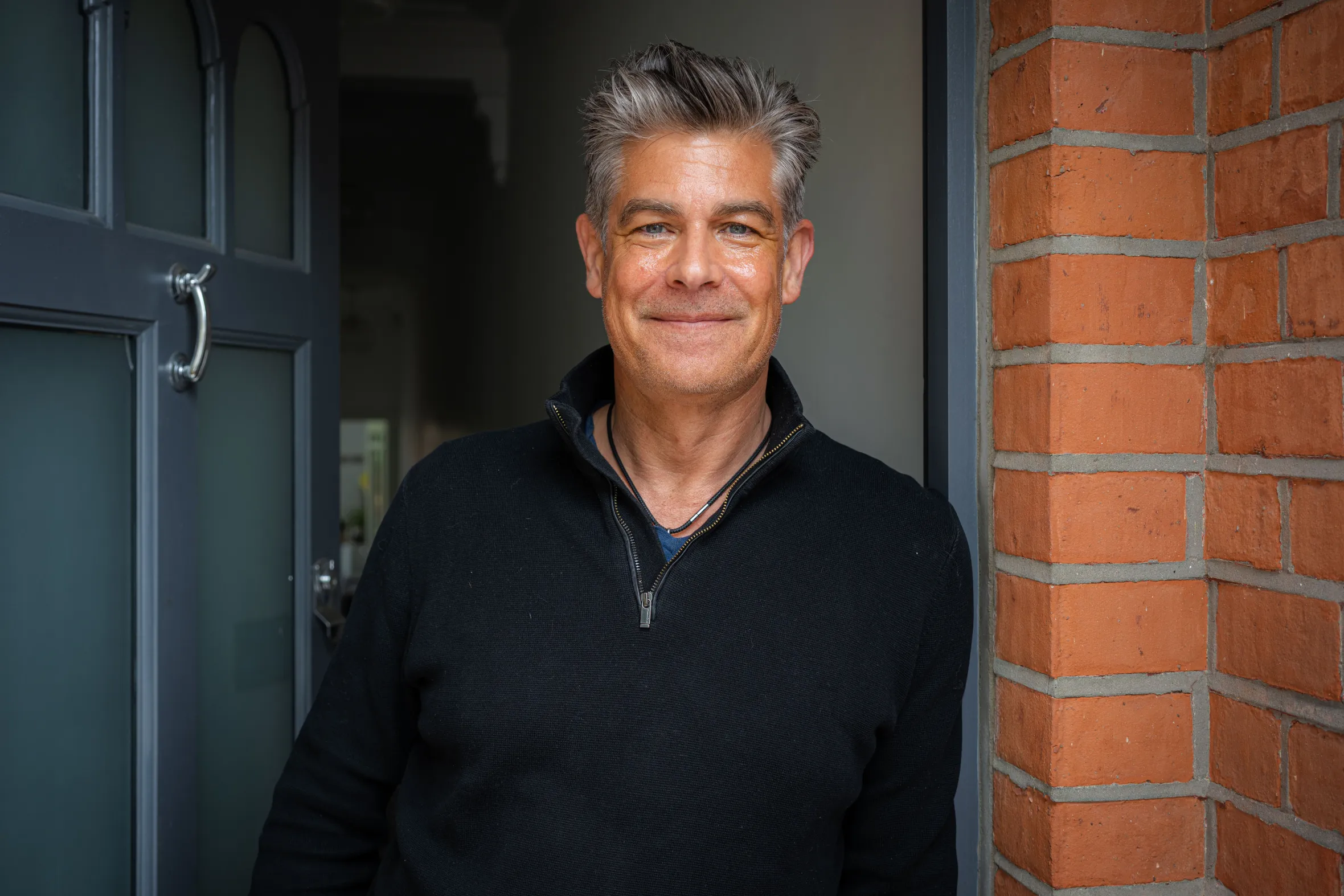 Home owner and architect Eric Haendler smiles at the camera, standing in a doorway.