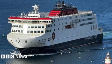 The Manxman ferry, which is white, red and black and has Steam-Packet.com on the side, entering Douglas Harbour.
