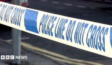 Generic close-up shot of a police cordon with blue writing on a white background