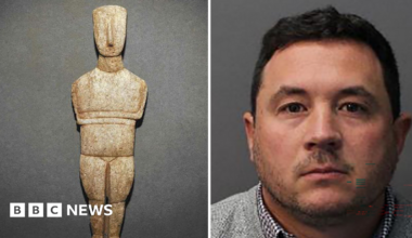 Composite image showing a mug shot of Andrew Crowley to the right and one of the statues to the left. Crowley is wearing a light grey jumper and checked shirt underneath, he has short dark hair and short stubble.