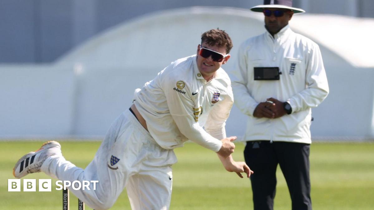 Jack Carson bowling for Sussex with an umpire standing in the background