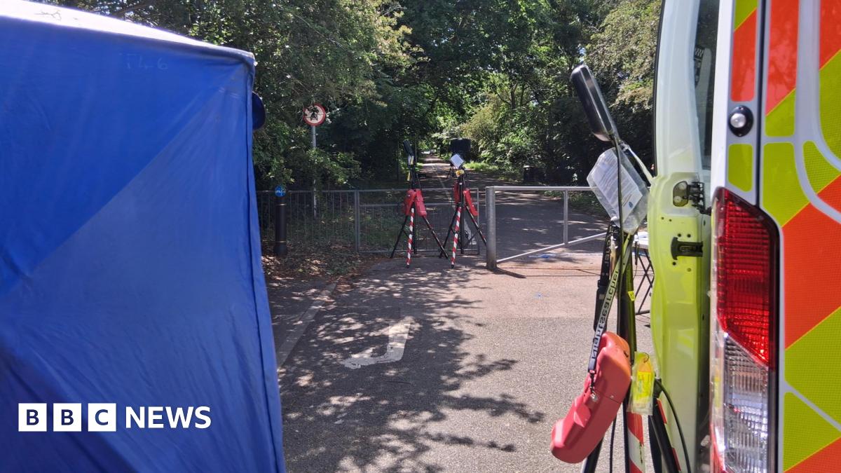 A police tent and van parked near an alleyway where floodlights have been set up.