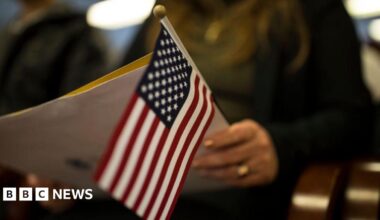 A newly sworn in US citizen holds a US flag while listening to a speech from a US government employee at a naturalization ceremony for new US citizens February 16, 2017 in Newark, New Jersey
