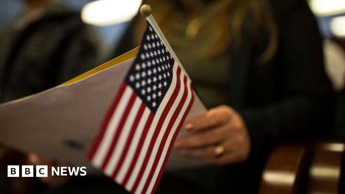 A newly sworn in US citizen holds a US flag while listening to a speech from a US government employee at a naturalization ceremony for new US citizens February 16, 2017 in Newark, New Jersey