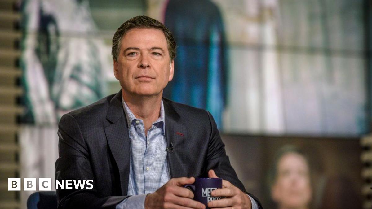 James Comey wears a suit and holds a mug on the set of NBC News' Meet the Press.