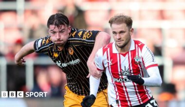 Hull defender Charlie Hughes has his left hand on the right shoulder of Southampton player Leo Scienza, who is wearing gloves