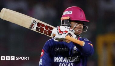Vaibhav Sooryavanshi holds his bat aloft after passing 50