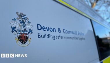 Side of a police van with the emblem and sign for Devon and Cornwall Police.