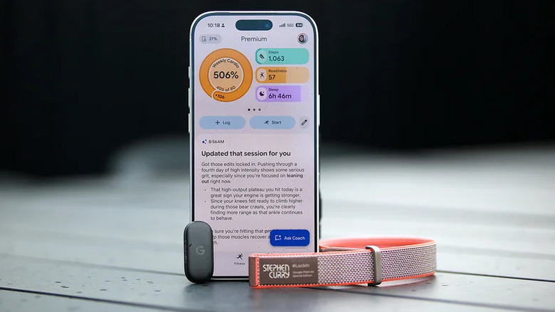 The Fitbit Air (device and band separated) sitting in front of a phone with the Google Health app.