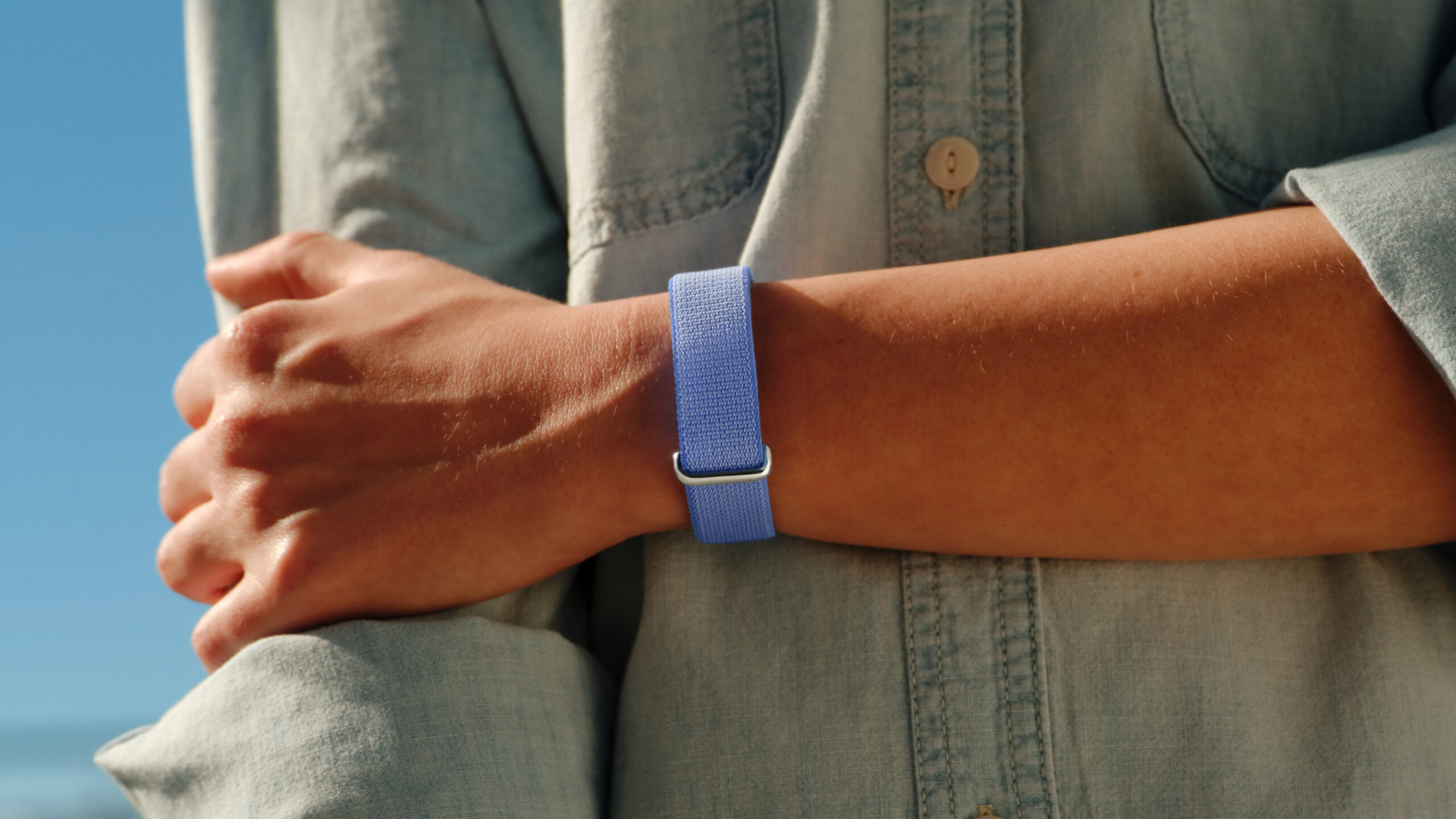 google fitbit air lifestyle official lavender on wrist A lifestyle photo of someone wearing the Google Fitbit Air in its Lavender color.
