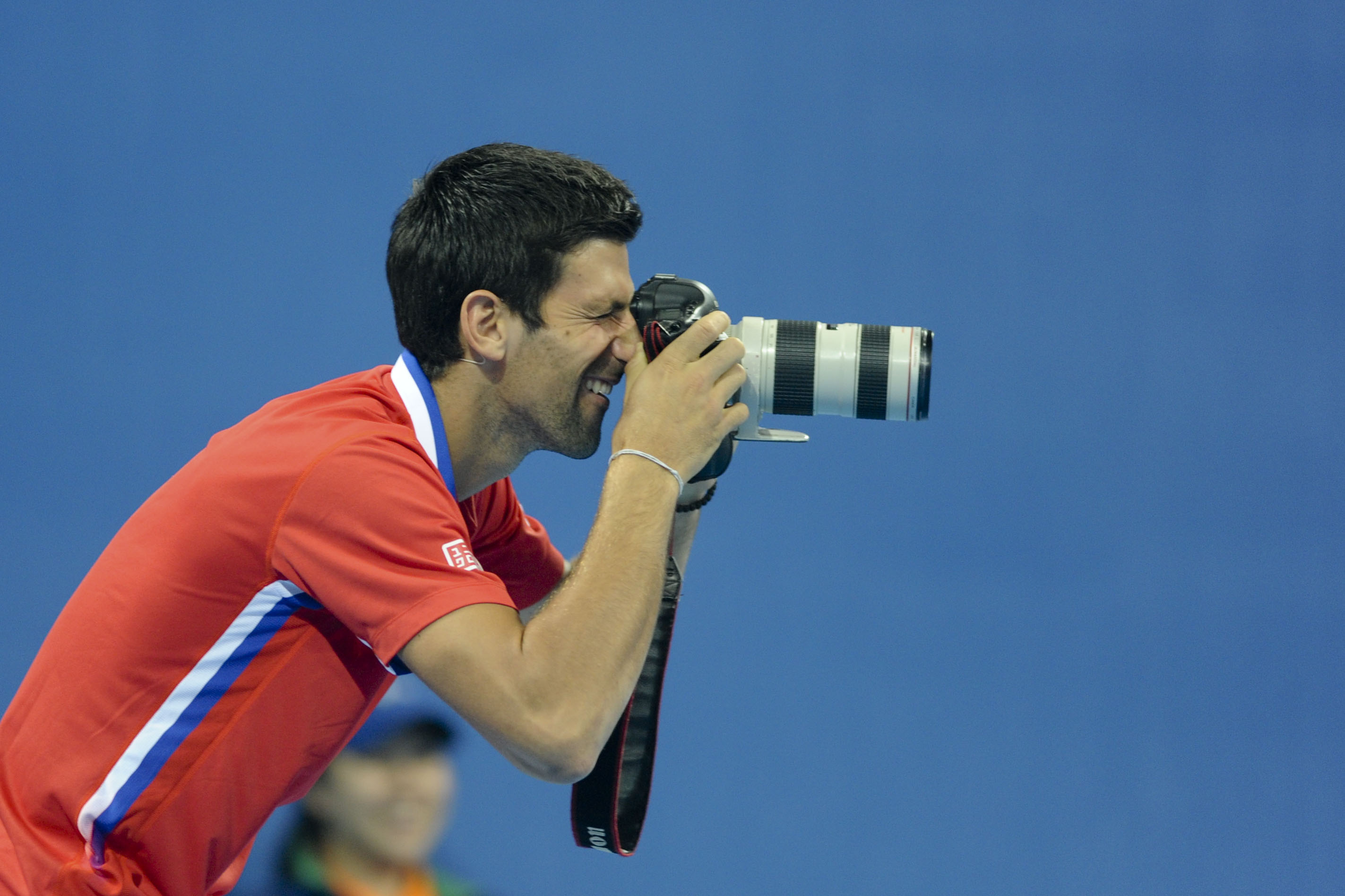 Serbian professional tennis player Novak Djokovic takes photos with a camera during a charity event ahead of the 2013 China Open at National Tennis Center on September 27, 2013 in Beijing, China.