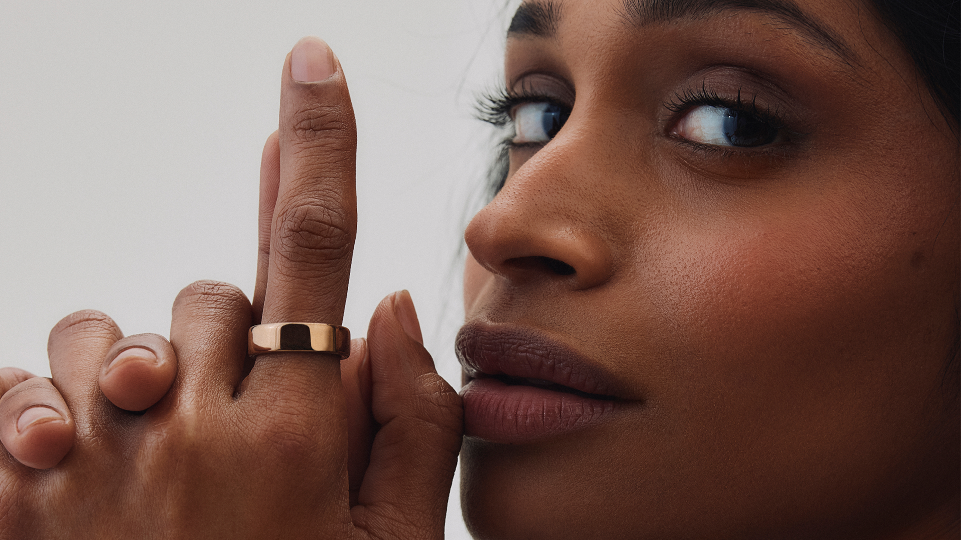 A women holds up her hand to her face wearing the Oura Ring 5