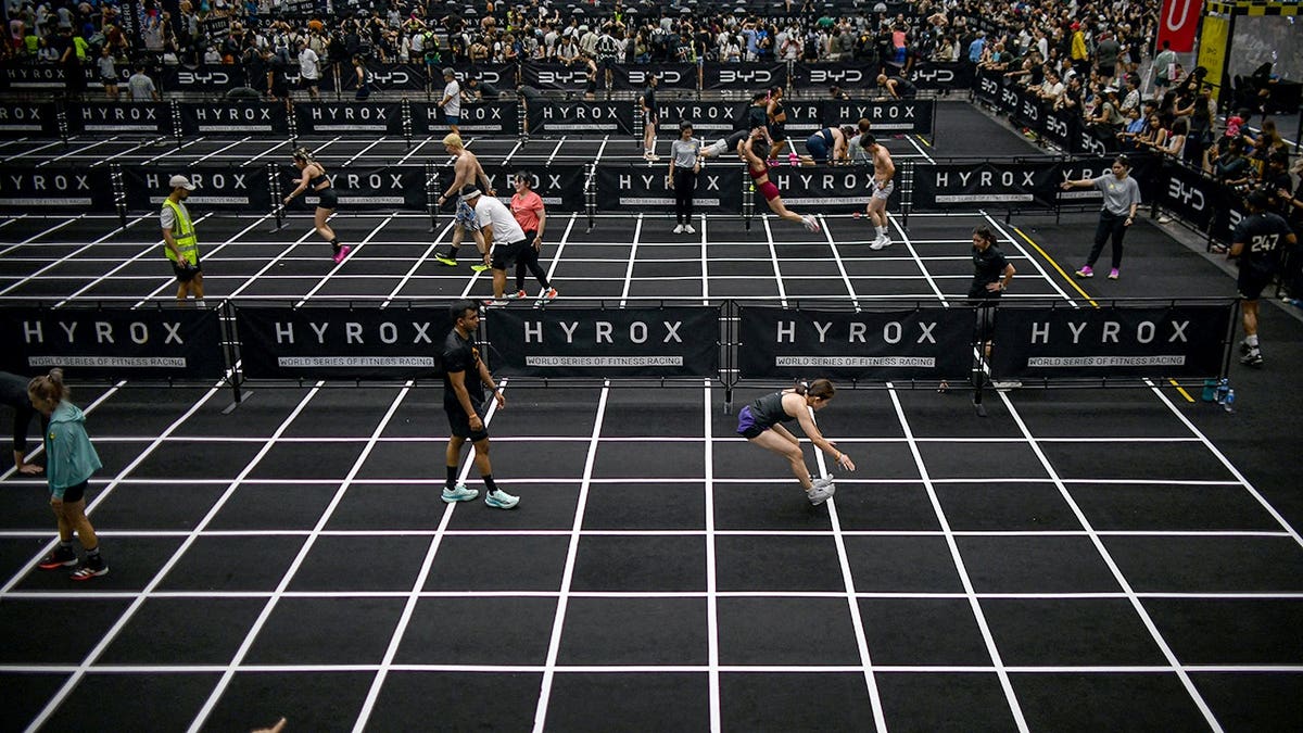 Participants performing burpee broad jumps at Hyrox fitness race in Bangkok