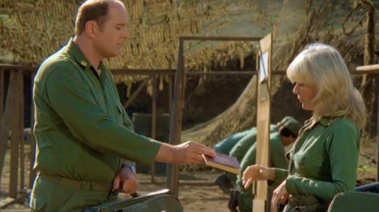 Charles hands Margaret a book on M*A*S*H