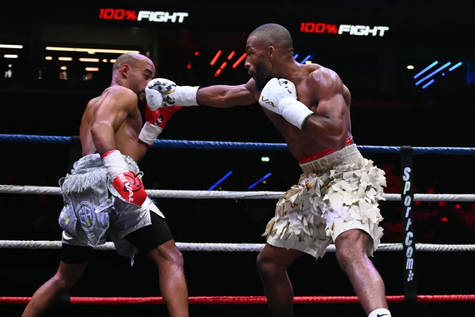 France's Salahdine Parnasse (R) lands a right hand on France's Franck PetitJean (L) during their Boxing Match at the Adidas Arena in Paris on October 4, 2025. This is the first Boxing match the Mixed Martial Arts (MMA) star is competing in since transitioning to the sport