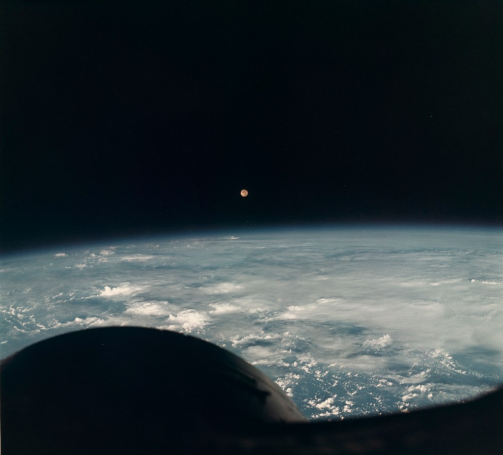 View of Earth, the Moon, and the nose of the Gemini VII spacecraft.
