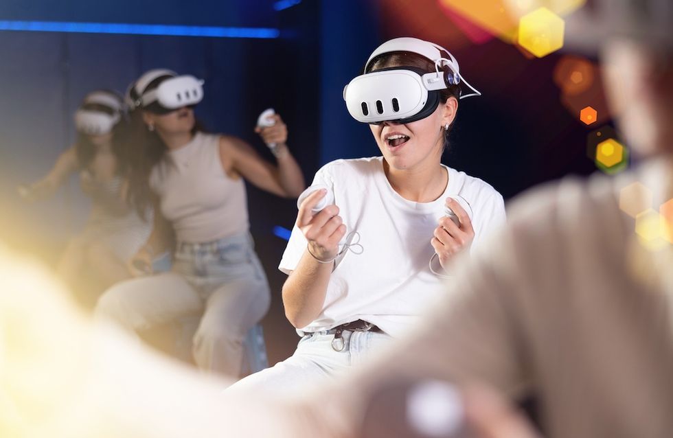 People enjoying a VR experience with headsets and controllers in a vibrant setting.