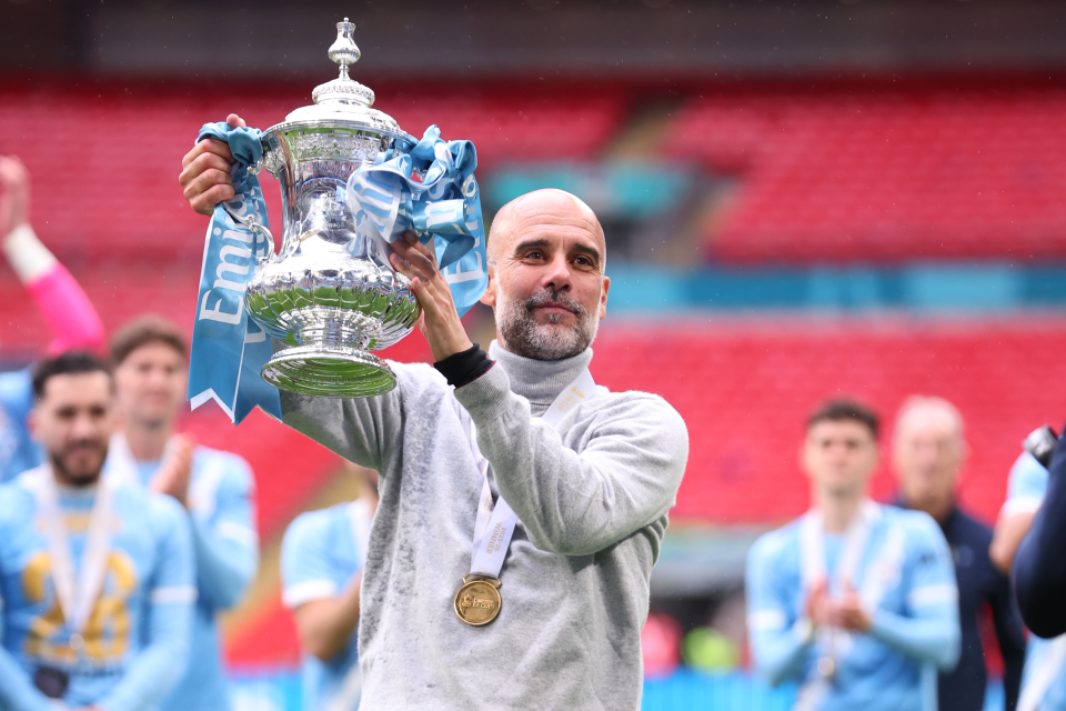 Pep Guardiola lifts the FA Cup.