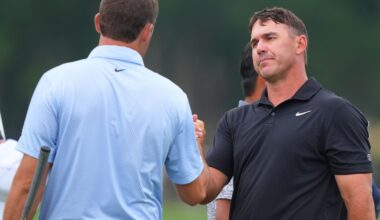 Brooks Koepka (R) shakes hands with Scottie Scheffler after finishing their first rounds