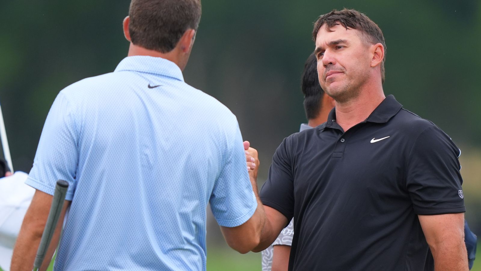 Brooks Koepka (R) shakes hands with Scottie Scheffler after finishing their first rounds