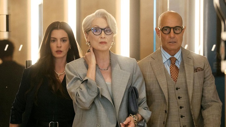 Anne Hathaway as Andy, Meryl Streep as Miranda, and Stanley Tucci as Nigel walking together in The Devil Wears Prada 2