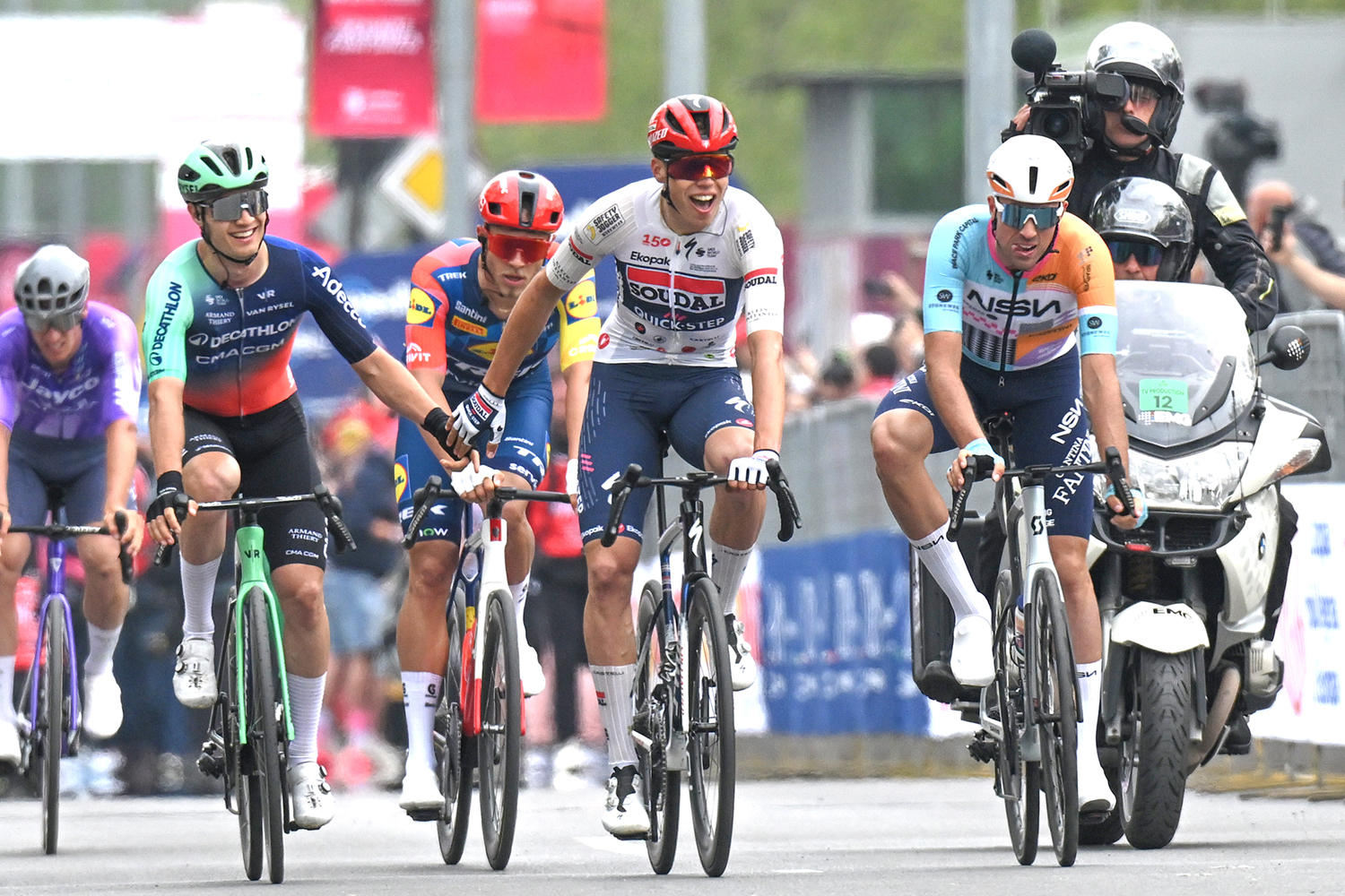 Paul Magnier (centre) wins stage 3 of the 2026 Giro d'Italia, beating Tobias Lund Andresen (left) and Ethan Vernon (right) to the finish line