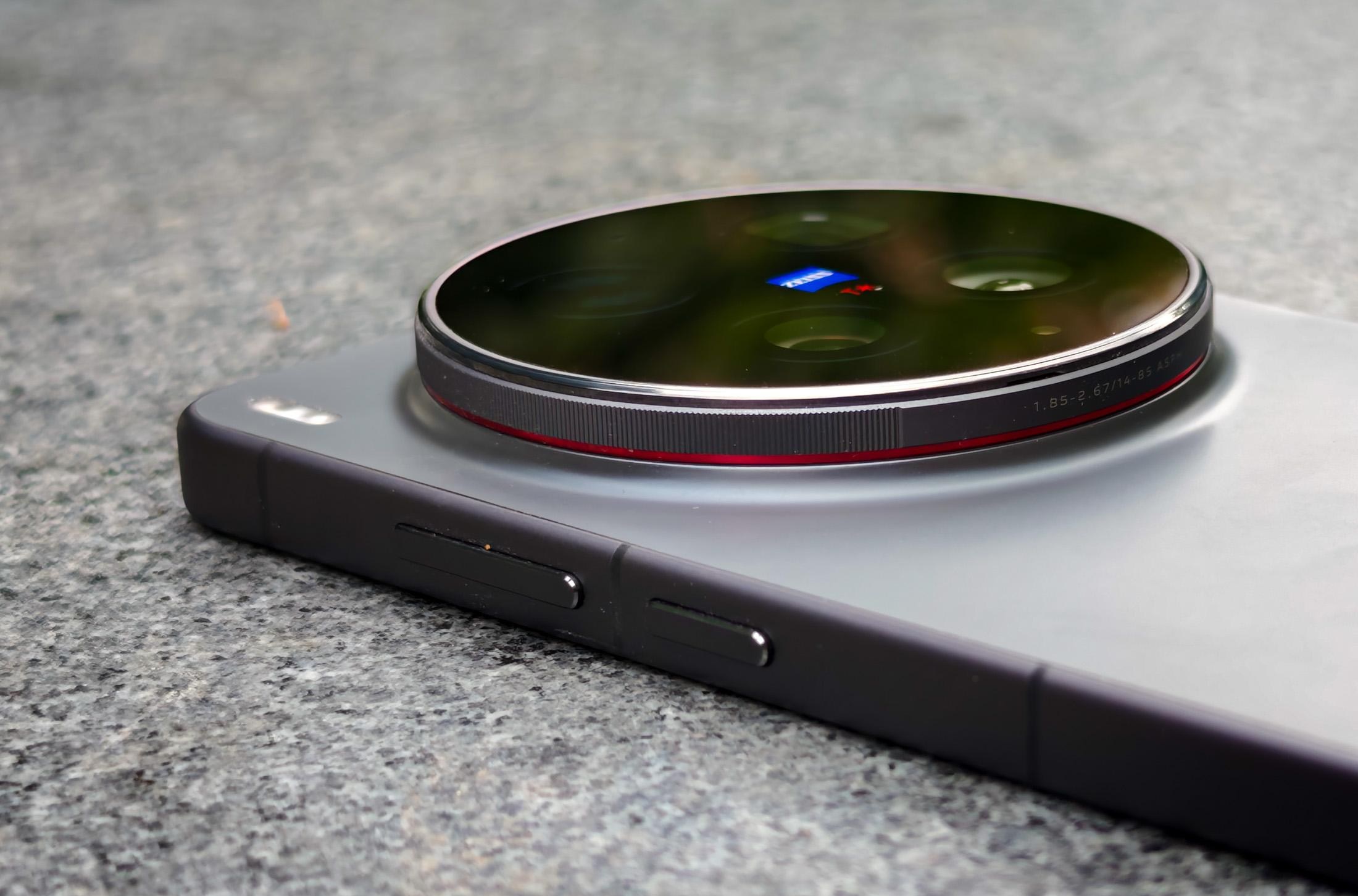 Photo of the Vivo X300 Ultra camera laying on a gray stone bench, focusing on the camera module which has a red ring around it and is distinctively thick.